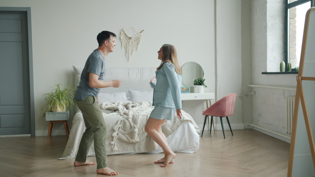 행복한 커플이 침실에서 춤을 춘다