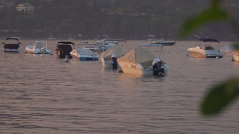 Boats-are-Swinging-at-Anchor-in-Lake-Garda-in-Northern-Italy-in-a-Beautiful-Sunset