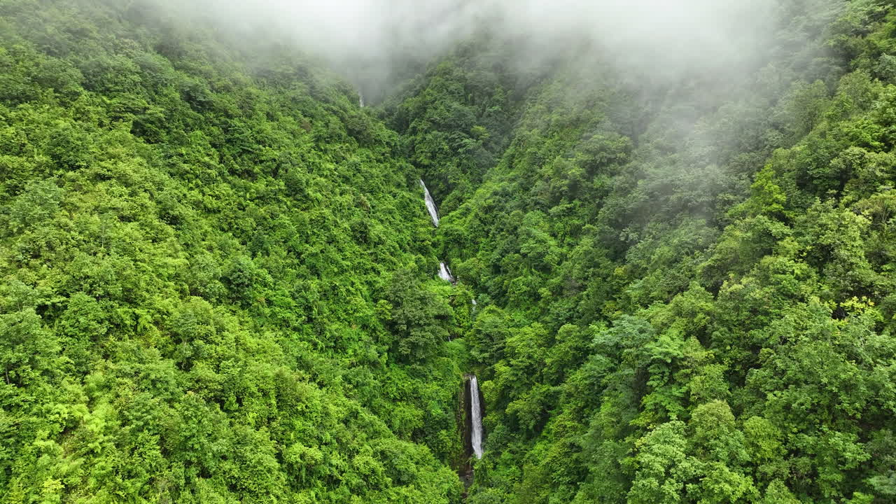 Lush Green Mountains with Cascading Waterfalls and Mist