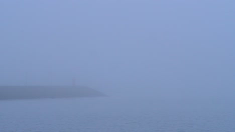 Nebel-über-Meer-Und-Küstenstadt-Bei-Sonnenaufgang-Mit-Ruhigem-Wasser-Und-Buntem-Himmel