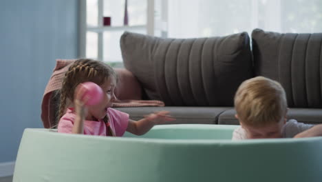 Girl-with-braids-throws-balls-at-younger-brother-emotionally