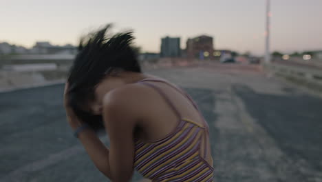 mujer bailarina atractiva bailarina callejera hispana en la ciudad realizando movimientos contemporáneos de hip hop disfrutando de la expresión de danza moderna al atardecer de cerca