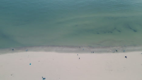 Vista-Desde-El-Dron---Gente-Irreconocible-Caminando-Por-La-Playa-De-Arena-Blanca-Cerca-Del-Mar-Báltico-En-La-Ciudad-De-Sopot-En-El-Norte-De-Polonia