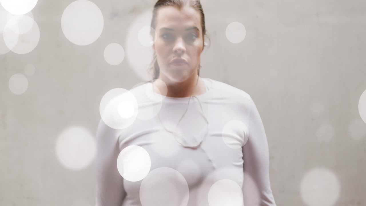 анимация светлых пятен над плюс-размером белая женщина в спортивной одежде сгибает мышцы