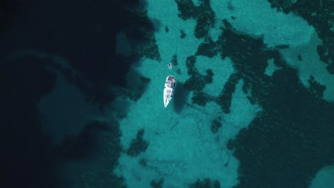 Yacht-boat-ship-sailing-at-pristine-turquoise-clear-water-beach-bay-on-Palma-de-Mallorca-Island