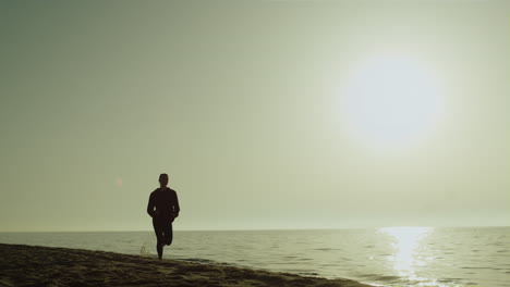 Silhouette-Sportlerin-Läuft-Am-Meeresufer.-Mädchen-Joggt-Am-Sandstrand-Bei-Sonnenuntergang.