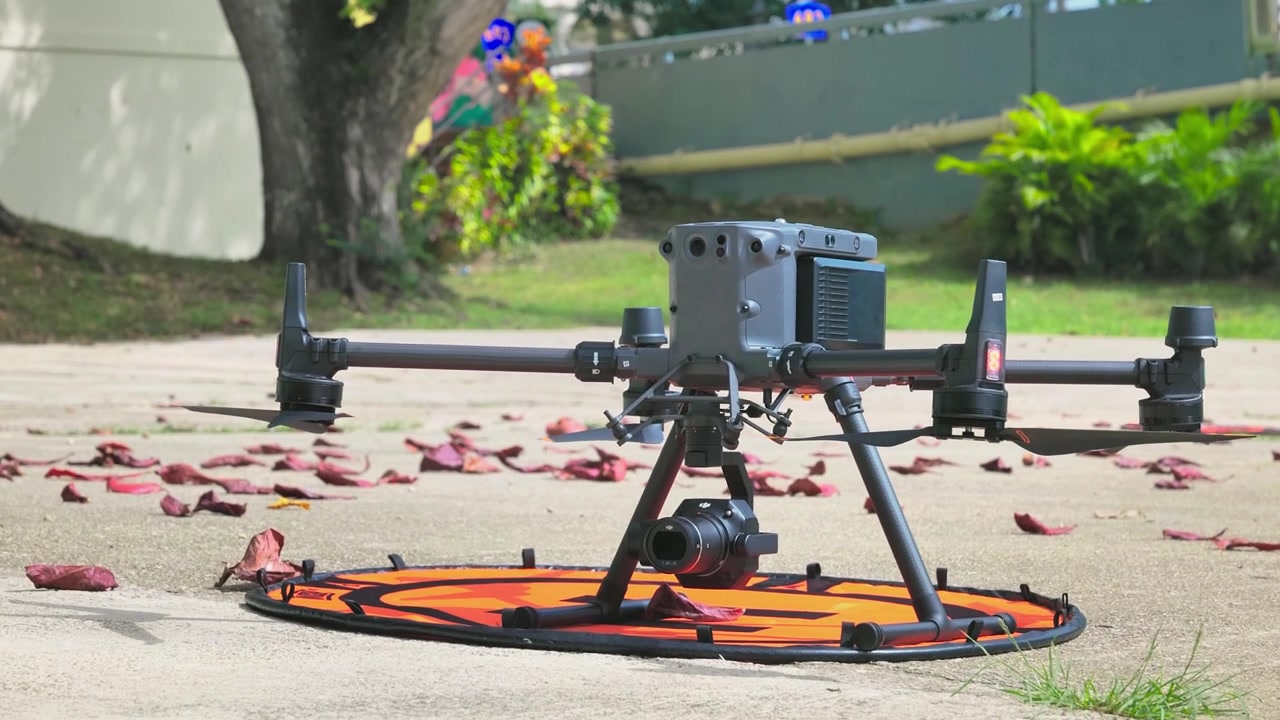Riprese 4K di un drone DJI Matrice 300 RTK acceso e posizionato a terra all'aperto. Mostra attrezzatura aerea professionale. Per tecnologia, produzione cinematografica, attrezzature