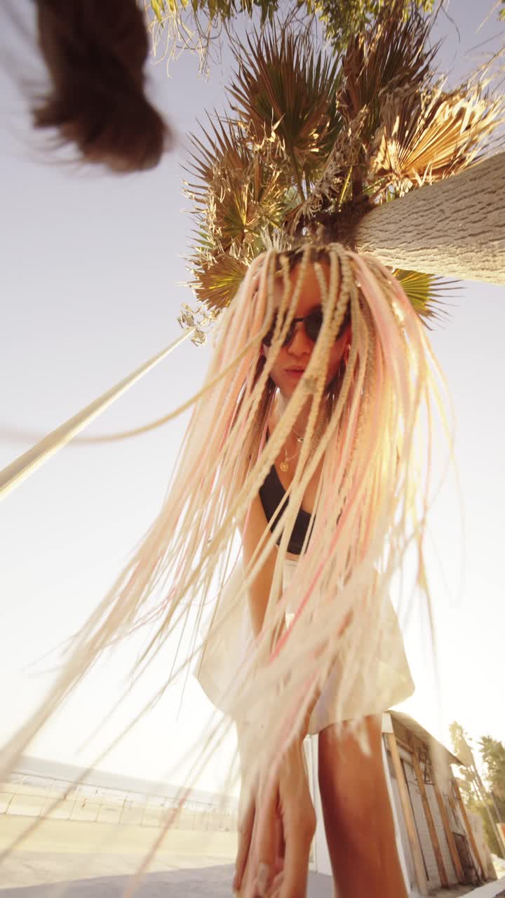 Woman in white dress near palm tree on beach