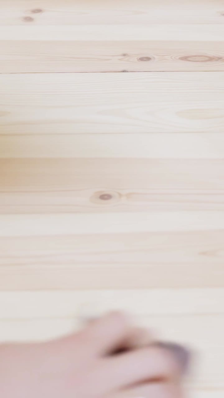 Close-up of a hand polishing a wooden surface during a DIY home renovation project