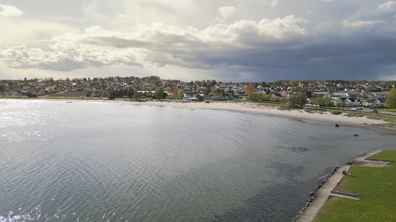 Aerial pan view Ringshaugstranda Beach under a cloudy sky, located near Tønsberg in Norway.