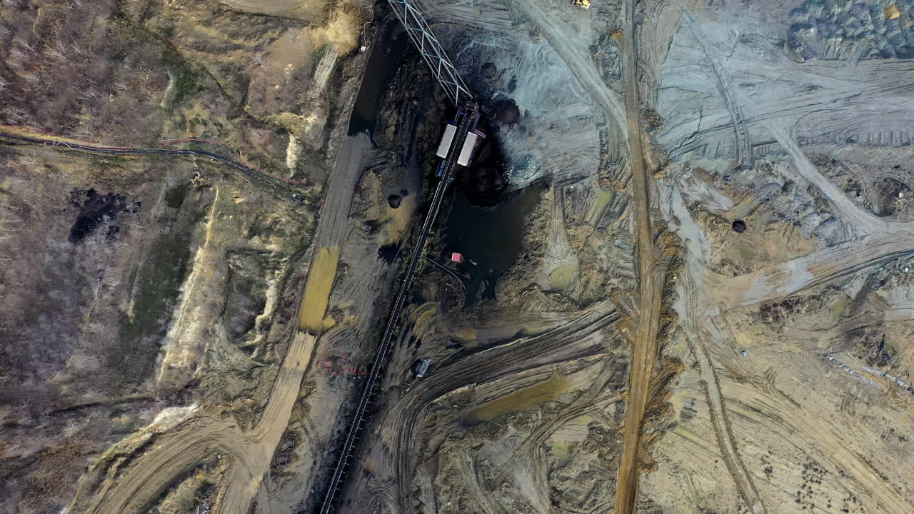 Aerial view of opencast mining quarry in the middle of the forest