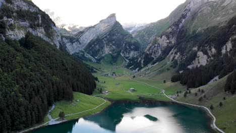 Sobrevuelo-Aéreo-Sobre-El-Lago-Seealpsee-En-Appenzell,-Suiza-Con-Un-Reflejo-De-Los-Picos-Alpstein-En-El-Lago-Con-Movimiento-Inverso-Que-Revela-Las-Orillas-Y-El-Final-Del-Lago