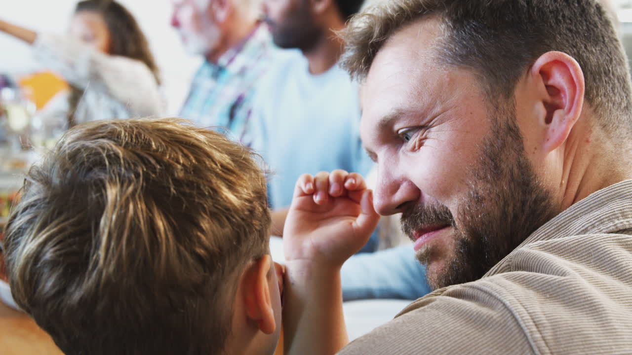 아버지와 아들의 대화: 다세대 가족이 집에서 함께 식탁에 앉아 식사를 즐긴다.