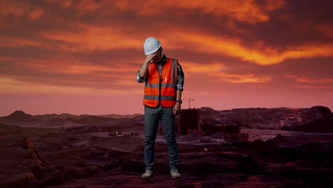 cuerpo lleno de ingeniero masculino asiático con casco de seguridad que tiene dolor de cabeza mientras trabaja en el sitio de construcción, maquinaria de minería