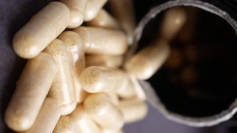primer plano de una pila de pastillas o cápsulas blancas derramadas de una botella