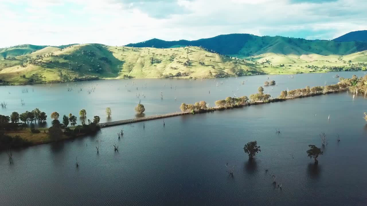 Drone view of the Murray Valley Highway crossing the swollen floodplains of the Mitta Mitta River as it enters Lake Hume, in north-east Victoria, Australia. November 2021.
