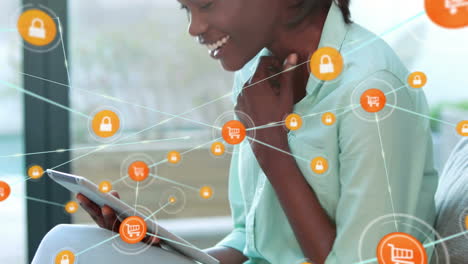 animation of network of connections with trolley icons over african american woman using tablet