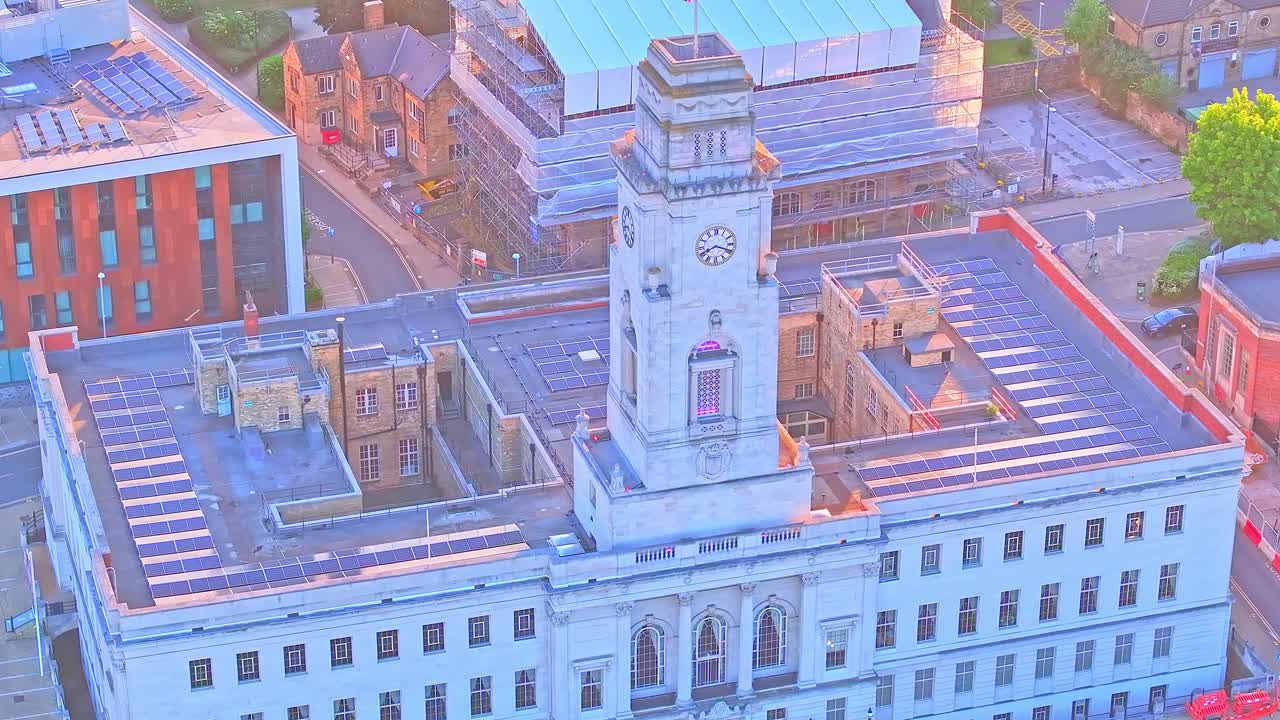 Aerial fly national English flag waving over Town Hall, clock tower building, station in South Yorkshire, near Barnsley Town Centre - Civic Gardens Area
