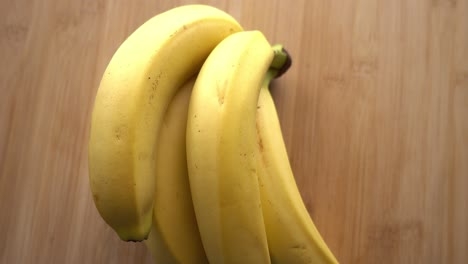 banana bunch rotating on wooden background