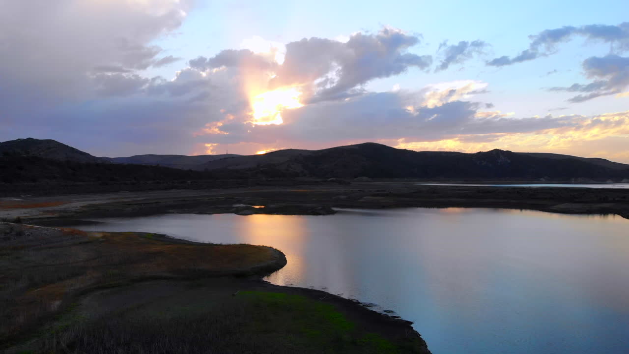 hermosa puesta de sol tirando hacia atrás del dron aéreo sobre el embalse del lago irvine, que es muy bajo debido a la sequía