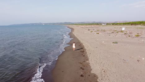 Mujer-Solitaria-En-La-Playa-De-Arena-Contaminada-En-Albania---Dolly-Adelante