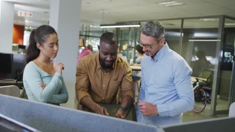 diverse male and female business colleagues talking and using tablet