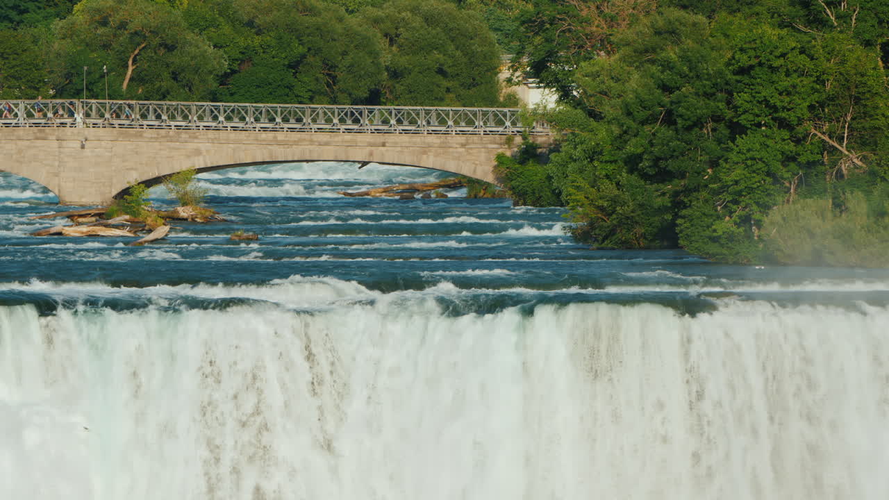 나이아가라 폭포와 관광객들이 걷는 나이아가라 강 건너 다리