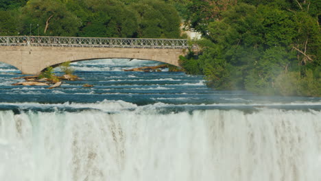 niagara falls and the bridge across the niagara river where tourists walk