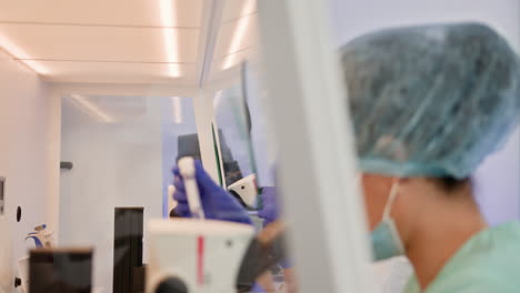 científicos que trabajan en un laboratorio usando microscopios