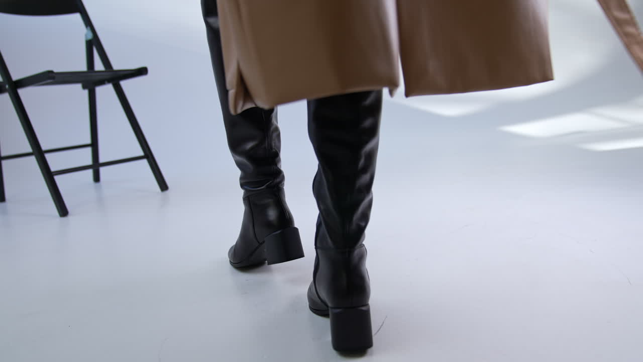 Woman wearing high boots and trench coat