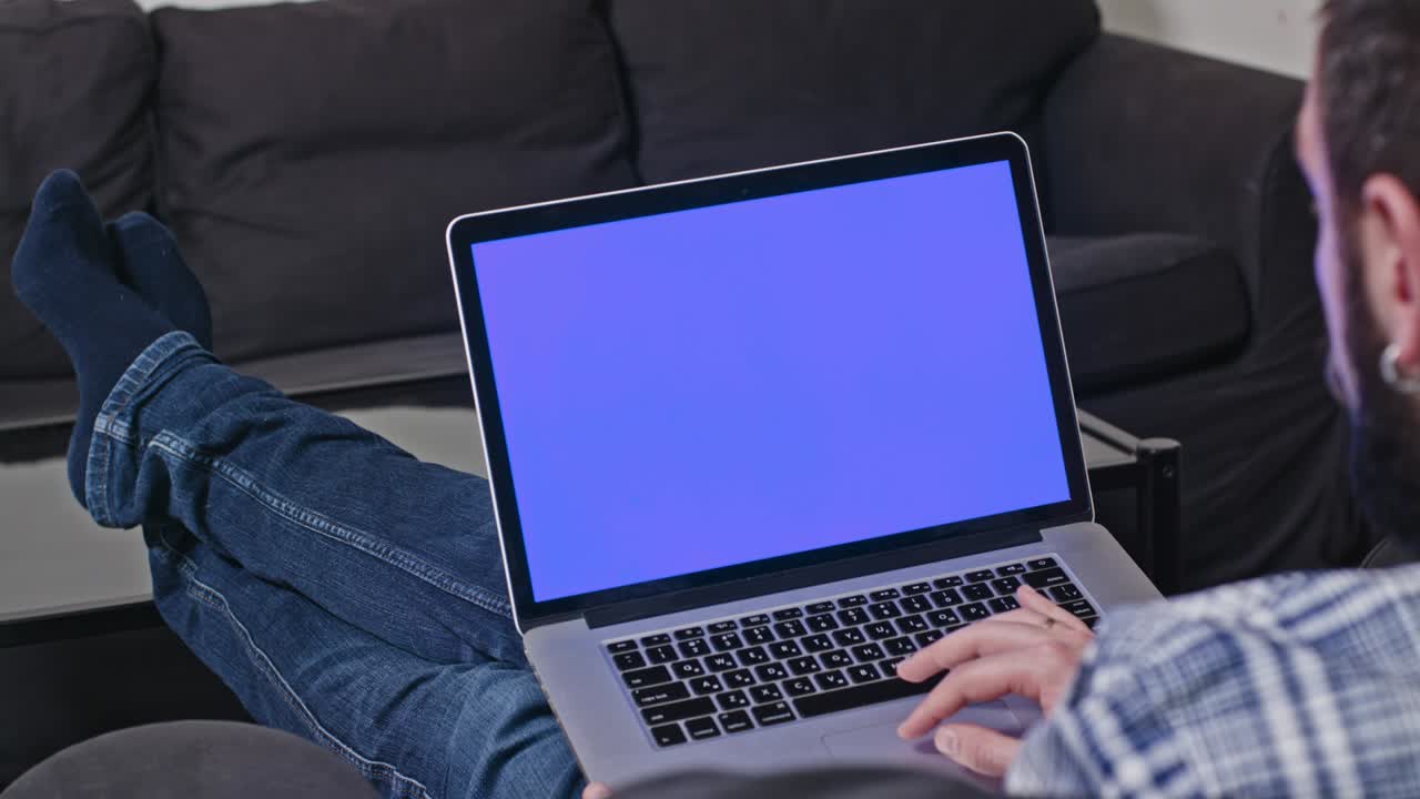 Uomo che lavora da casa al computer portatile