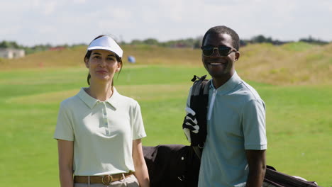 caucasian woman and african american man on the golf course.