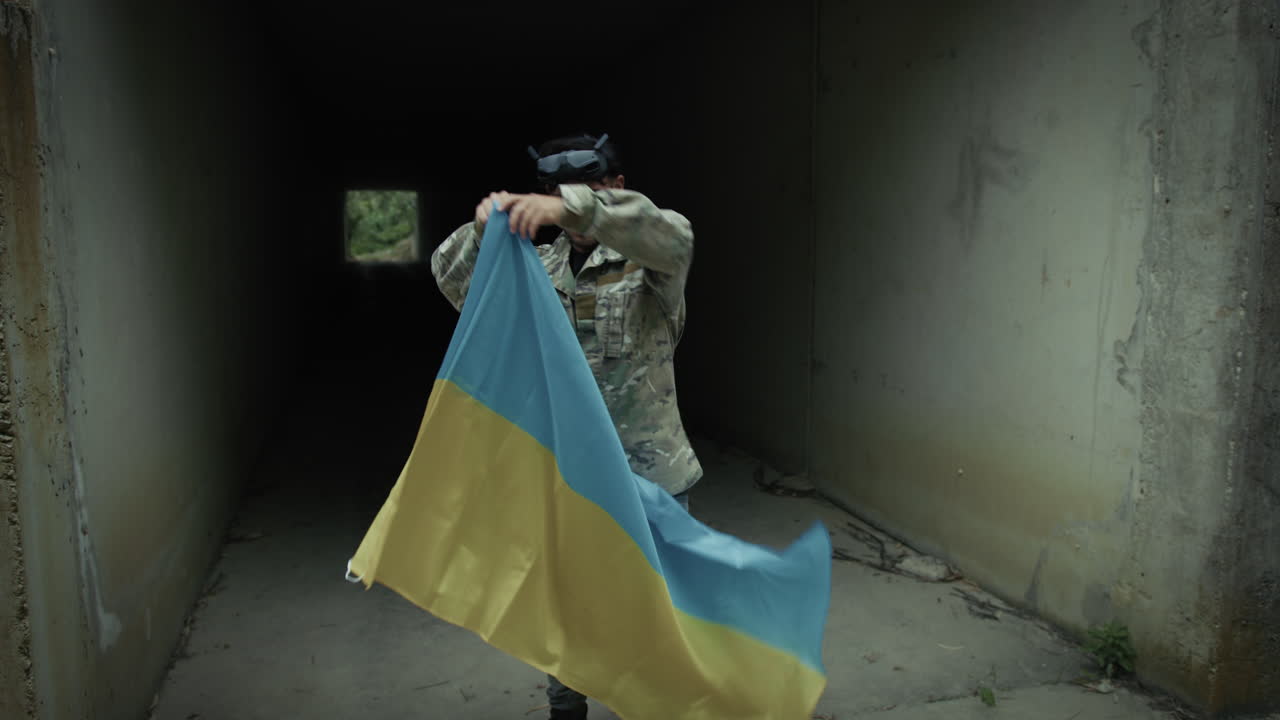 Ukrainian Military Drone Pilot Wears Flag as Cape Outside Bunker