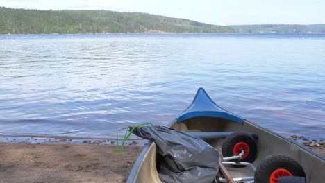 Handheld-upward-tilting-view-of-tranquil-water-landscape-from-a-canoe-on-the-shore,-in-summer