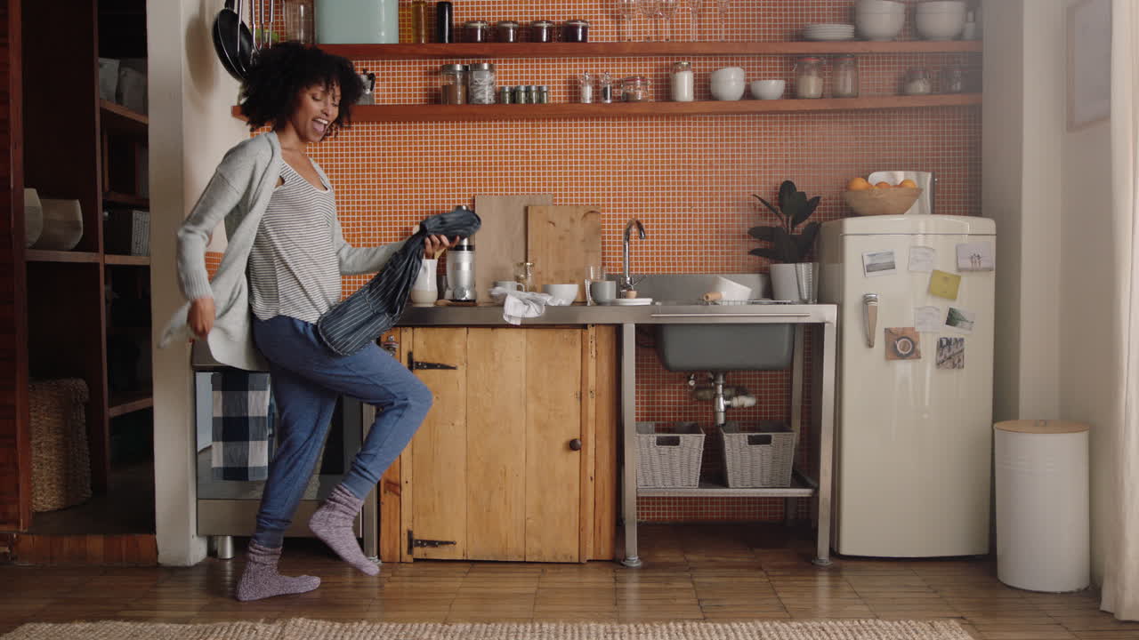 mujer feliz bailando en la cocina celebrando un estilo de vida exitoso disfrutando de una alegre celebración de baile de victoria