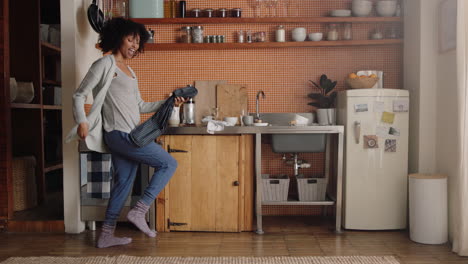 mulher feliz dançando na cozinha celebrando um estilo de vida bem sucedido desfrutando de uma alegre celebração de dança de vitória