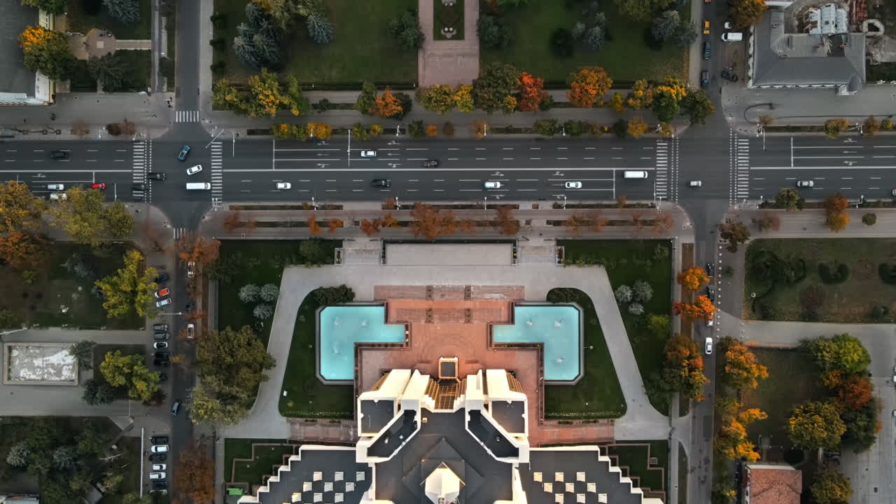 Aerial drone view of Chisinau downtown at sunset. Vertical view of Parliament and Presidency, road with moving cars and lush trees. Moldova