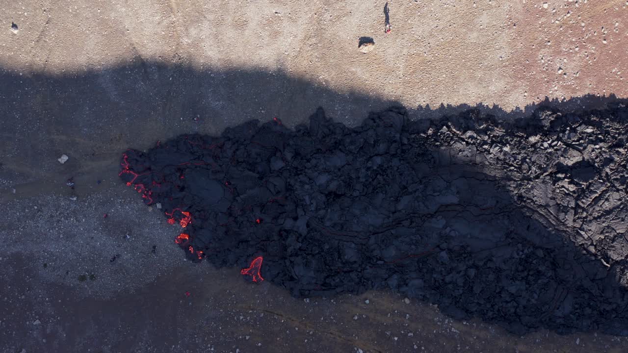 People standing close to slow moving viscous lava field, Fagradalsfjall, top down