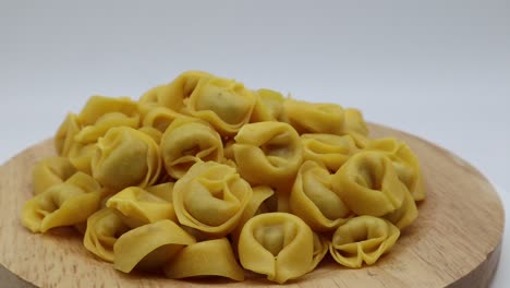 Rohe-Tortellini-Auf-Rotierendem-Display-Isoliert-Auf-Weiß