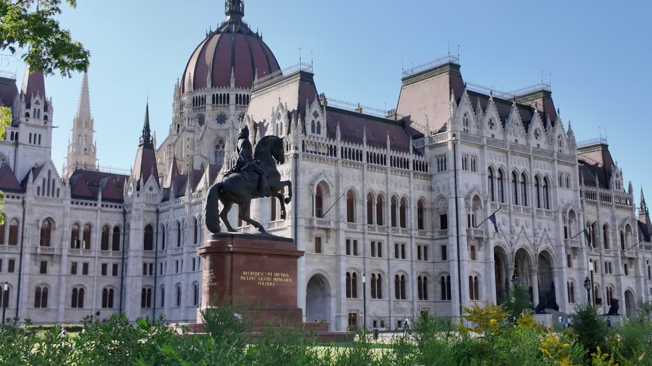 Equestrian statue of Francis I standing majestically in front of Hungarian Parliament Building in Budapest, Hungary, during a sunny summer day
