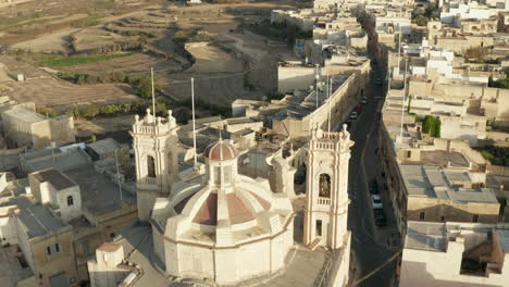 Braun-Beige-Kirche-Auf-Kleiner-Mediterraner-Stadt-Dorf-Kreuzungsstraße-Durch-Stadt-Auf-Malta,-Insel-Gozo-Aus-Luftdrohnenperspektive-Langsamer-Dolly-Vorwärts