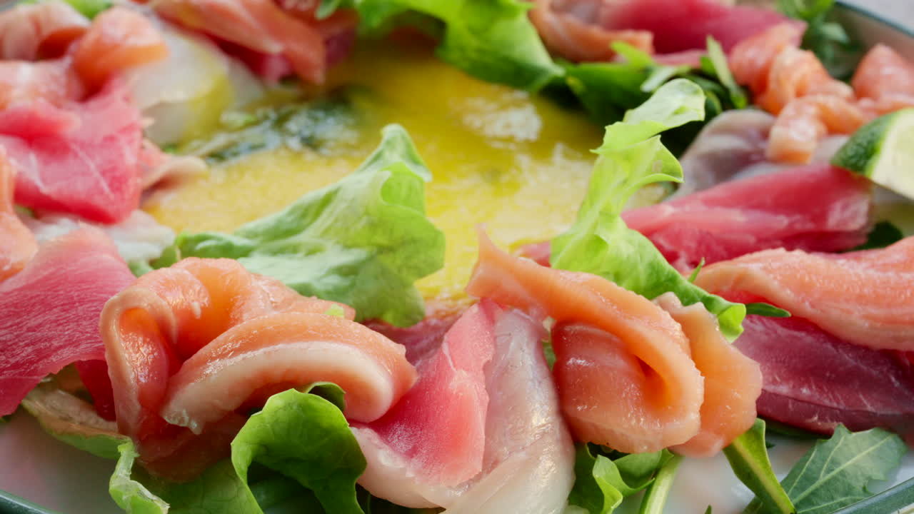 Close up of fresh raw fish slices with greens in a salad