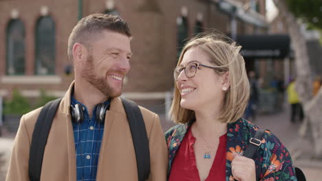 portrait of happy caucasian couple smiling happy at camera enjoying urban travel together