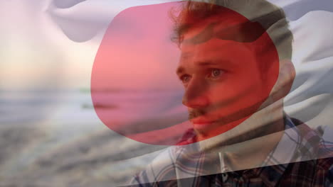 on beach, man with thoughtful expression observing animation of red and white shapes