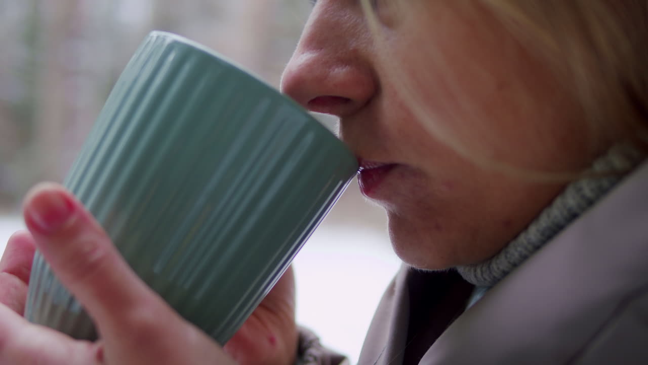 겨울 에 밖 에서 뜨거운 음료 를 마시는 여자