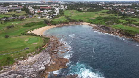 little bay beach rugged shoreline in sydney, new south wales, australia - aerial pullback