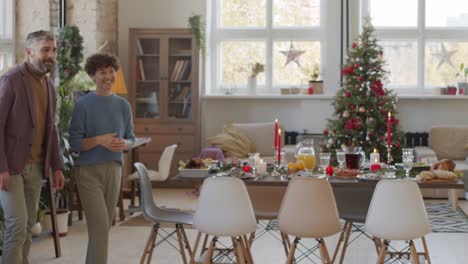 Paar-Begrüßt-Zwei-Freunde-Im-Wohnzimmer-Mit-Weihnachtsdekorationen