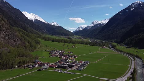 picturesque mountain village in green valley between steep alpine mountains, aerial