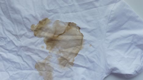 close-up of a coffee stain on a white t-shirt