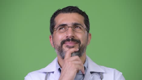 handsome happy persian bearded man doctor smiling and thinking